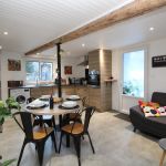 Pièce de vie avec cuisine équipée, coin repas et espace détente. Pièce de vie avec cuisine équipée, coin repas et espace détente.